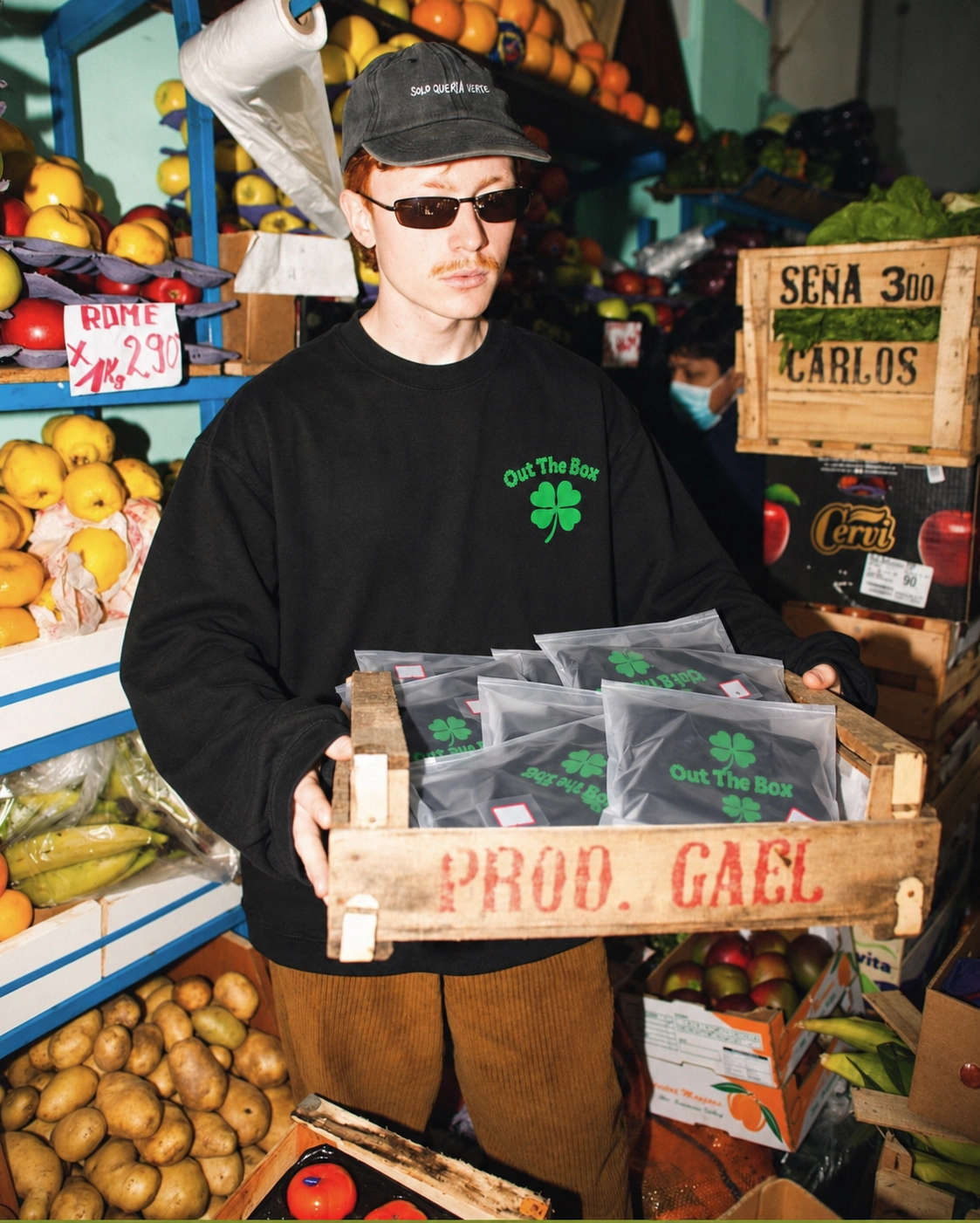 Model in de Lucky longsleeve met een krat OTBX-pakketten op de markt